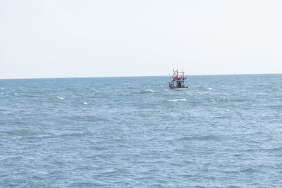 Sailboat sailing in sea against clear sky