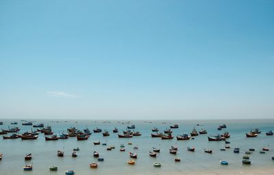 Boats in sea against clear blue sky, many boats