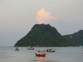 People on boat in sea against sky