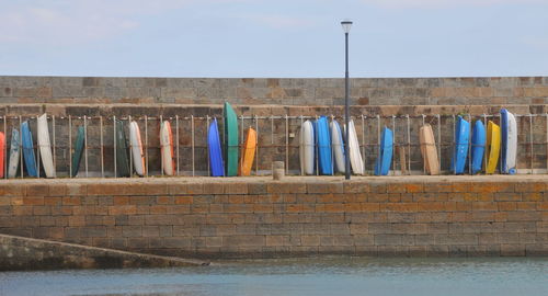 Clothes drying against wall against blue sky