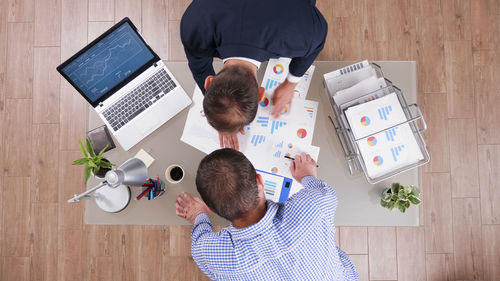 Rear view of man using laptop