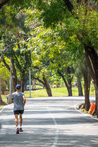 Rear view of man walking on road