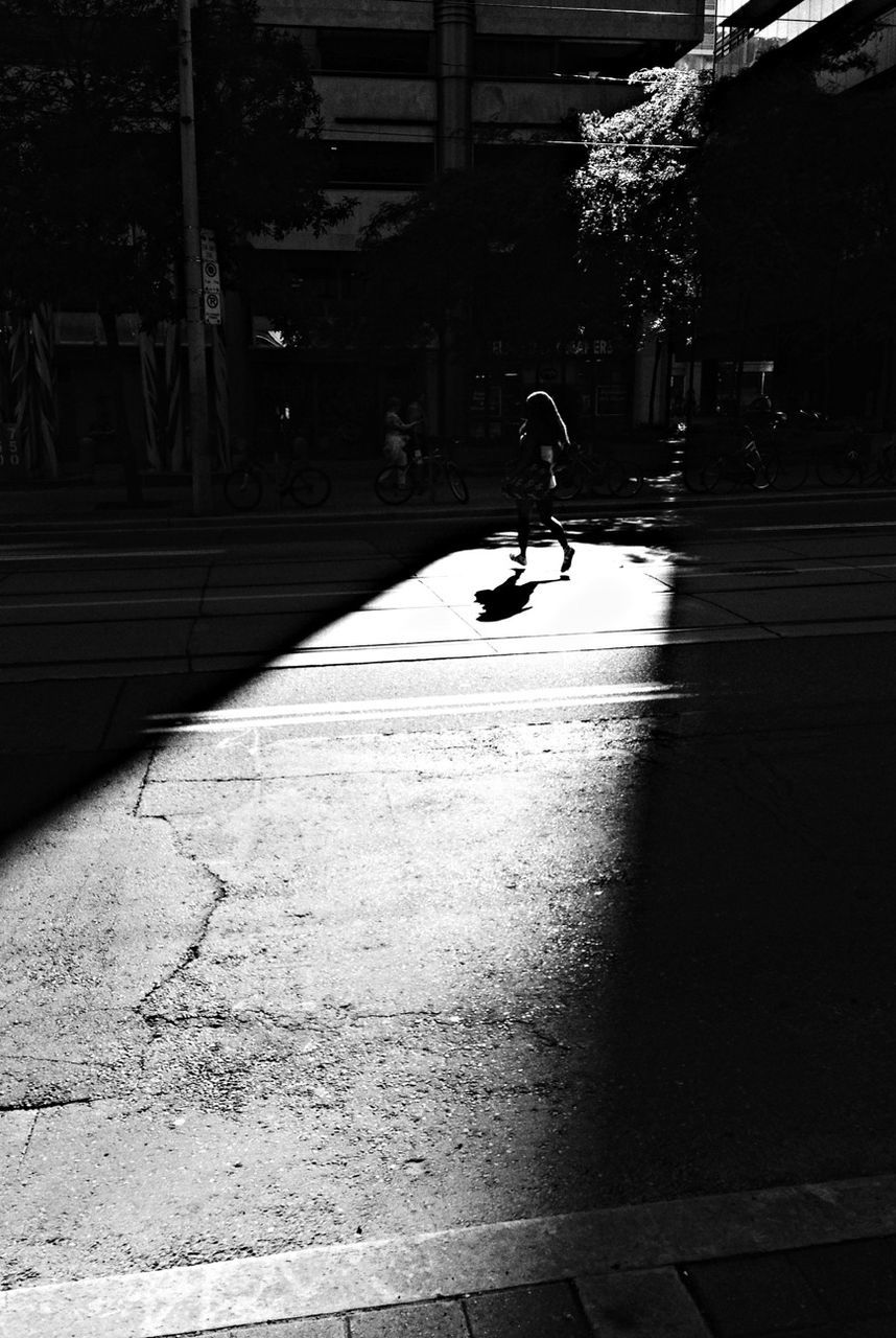 full length, lifestyles, walking, street, men, leisure activity, building exterior, built structure, sunlight, shadow, bicycle, architecture, city, motion, road, on the move, city life, person