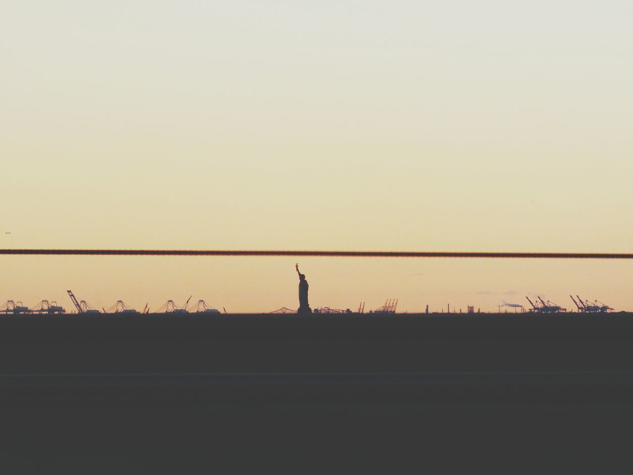 sunset, silhouette, copy space, clear sky, tranquil scene, tranquility, scenics, orange color, beauty in nature, landscape, nature, sky, connection, built structure, dusk, idyllic, outdoors, no people, power line, dark