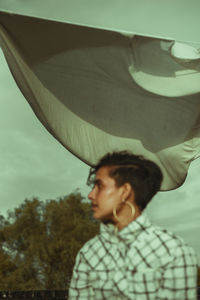 Portrait of boy looking down against sky