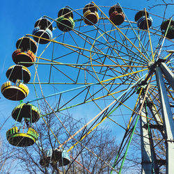 Low angle view of ferris wheel against blue sky