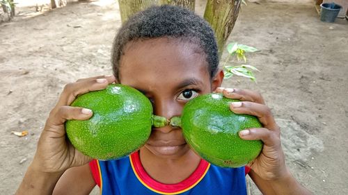 Midsection of boy holding avocados