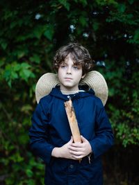 Portrait of boy standing against trees