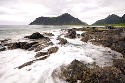 Scenic view of rocks in sea against sky