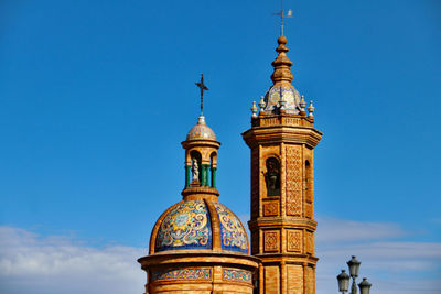 Low angle view of bell tower against blue sky