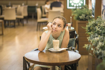 Portrait of woman sitting at restaurant table