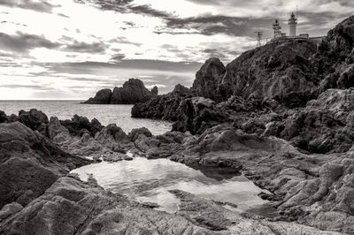 Scenic view of rocks on beach against sky