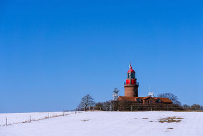 Lighthouse against clear blue sky during winter