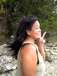 Mid adult woman looking away while standing on rock