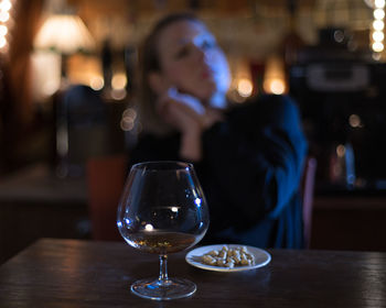 Mid adult woman sitting by wineglass and food on restaurant table