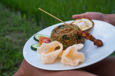 Close-up of hand holding food in plate