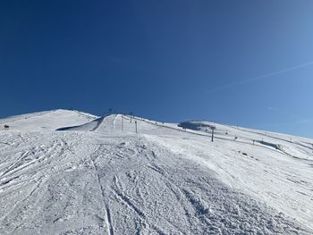 Scenic view of snowcapped mountains against clear blue sky