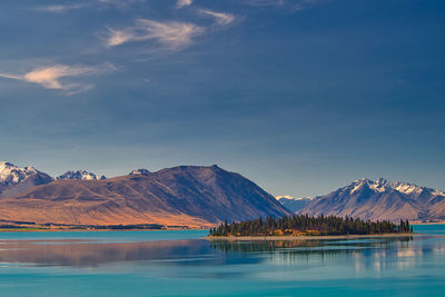 Scenic view of lake by mountains against sky