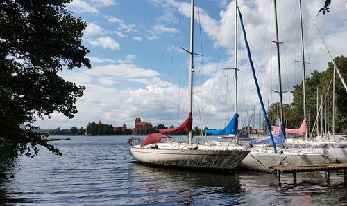 Boats moored on river against sky