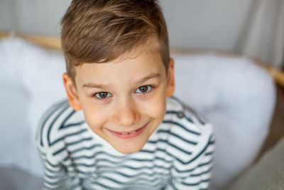 High angle portrait of smiling boy sitting at home