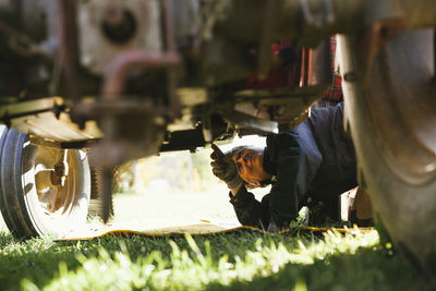 Woman repairing tractor