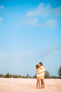 Rear view of couple standing on land against sky