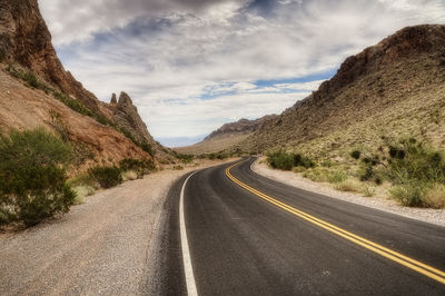 Road amidst mountains against sky