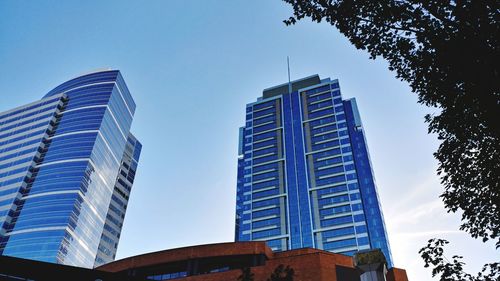 Low angle view of skyscrapers against clear blue sky