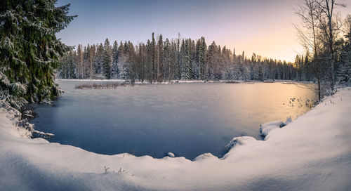 Frozen lake against sky during winter with snow