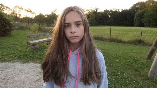 Portrait of girl with long hair while standing on field