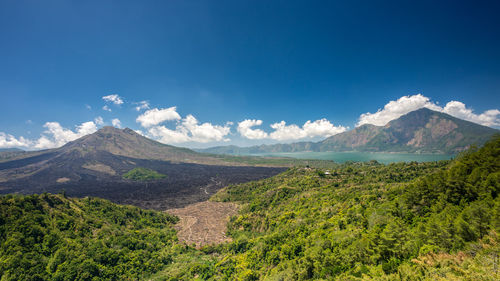 Scenic view of landscape and mountains against blue sky