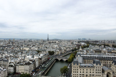 High angle view of city buildings against cloudy sky