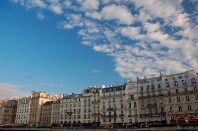 Low angle view of buildings against cloudy sky