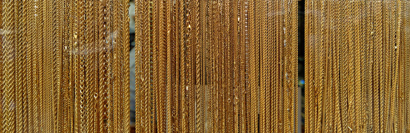 Full frame shot of gold chains hanging in store