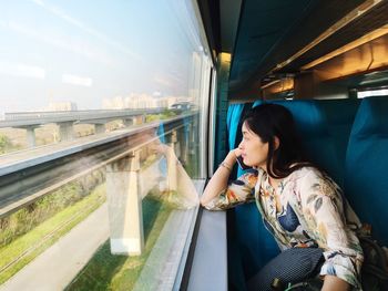 Rear view of woman looking through train window
