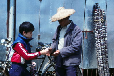 Side view of two people with bicycle