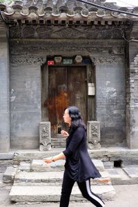 Side view of woman in front of building