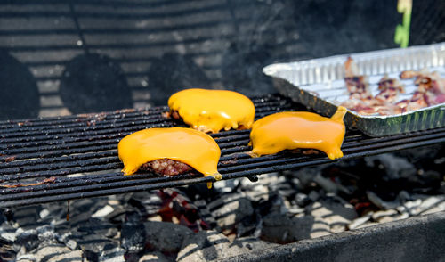 Close-up image of delicious juicy burgers on grill. melting yellow cheese on beef burgers.