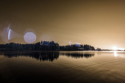 Scenic view of lake against sky at night