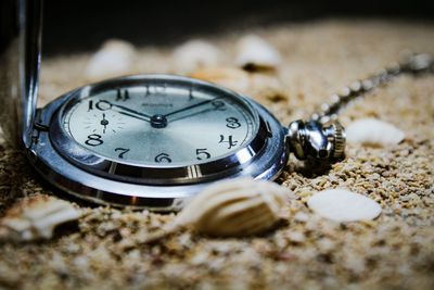 Close-up of clock on sand