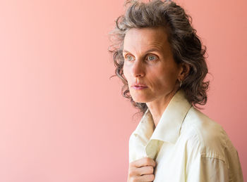 Close-up portrait of mature woman against gray background