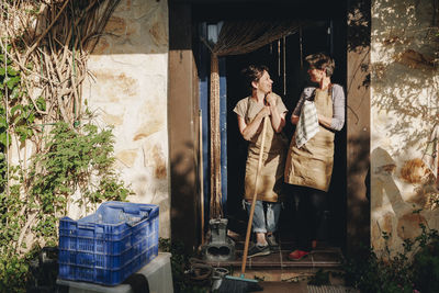 Entrepreneur with colleague standing in doorway on sunny day