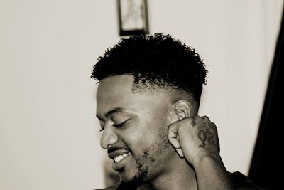 Portrait of young man looking away against white background