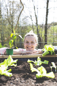 Smiling woman leaning on raised bed in yard