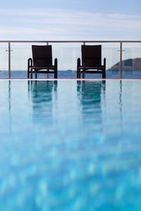 Swimming pool by sea against sky