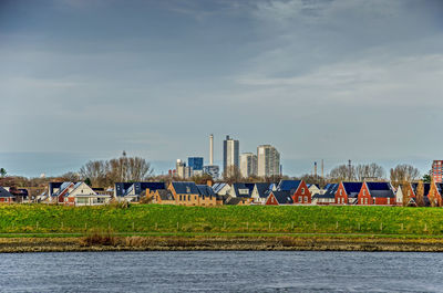 View across the river spui towards suburban eighbourhoods of spijkenisse behind the dike