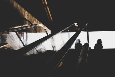 Low angle view of silhouette people on escalator