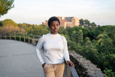 Portrait of young woman standing on road