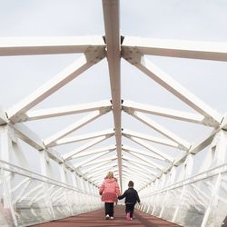 Full length rear view of woman standing by railing