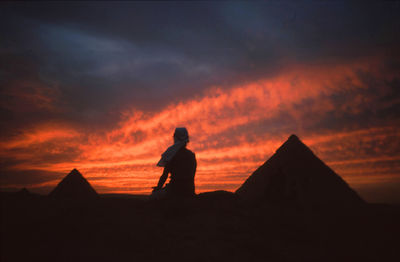 Silhouette man looking at sunset